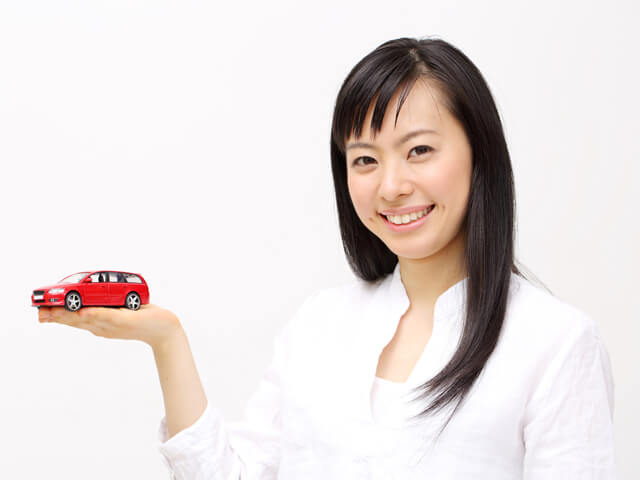 女性がミニカーを手にする様子